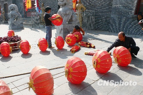 8月31日，河南省開(kāi)封市天波楊府門(mén)口，工作人員在準(zhǔn)備懸掛大紅燈籠。隨著“十一”國(guó)慶節(jié)和“十一”旅游黃金周的臨近，古城開(kāi)封的公園景點(diǎn)已早早開(kāi)始備戰(zhàn)，營(yíng)造喜慶祥和的旅游環(huán)境，迎接八方客人。 中新社發(fā) 李俊生 攝