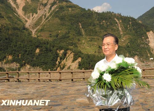 溫家寶總理十分關(guān)注災(zāi)后重建進(jìn)展情況。在國慶節(jié)和中秋佳節(jié)即將來臨之際，他第8次踏上了一直牽掛的這塊土地。在9月24日至26日的三天時(shí)間里，他奔波穿行于地震重災(zāi)區(qū)的城鄉(xiāng)間，為節(jié)省時(shí)間，吃飯盡量安排在火車上；連續(xù)兩個(gè)晚上主持召開會(huì)議，就災(zāi)后恢復(fù)重建的一系列重大問題進(jìn)行研究部署。這是9月24日，溫家寶在青川縣紅光鄉(xiāng)東河口村地震遺址祭奠臺(tái)獻(xiàn)花。新華社記者黃敬文攝