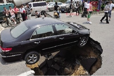 4日，南昌市昌南大道與迎賓北大道交叉口附近路面突然發(fā)生塌陷，一輛過(guò)路小轎車被卡在洞口處。圖/新華社
