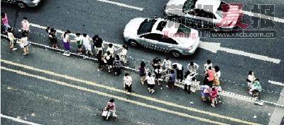 昨日下午5點，五一廣場附近，在車來車往的馬路中央，不少行人翻護(hù)欄穿越馬路。