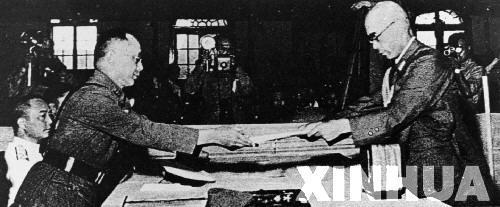 日本中國派遣軍總司令官岡村寧次在對華投降書上簽字，并向中方交出他的隨身佩刀，以表示侵華日軍正式向中國繳械投降。這是何應(yīng)欽(左)在南京代表中國政府接受侵華日軍總司令岡村寧次的投降書。新華社發(fā)
