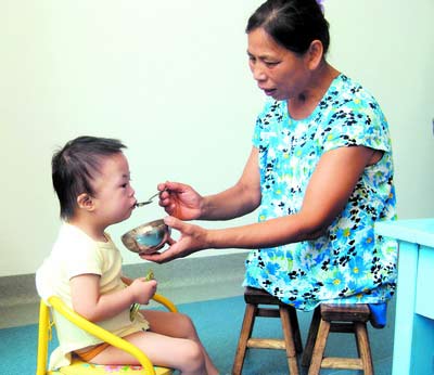 許月華在給孩子喂飯。劉炬 攝