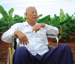 陳光保在自己的農(nóng)場(chǎng)里，他身后就是一片香蕉林(中青報(bào)蔣昕捷供圖)