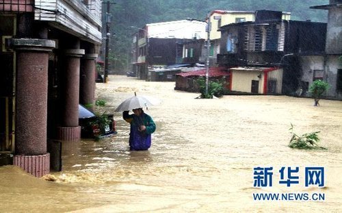 10月21日，臺(tái)灣宜蘭縣蘇澳地區(qū)居民在洪水中艱難出行。新華社發(fā) 