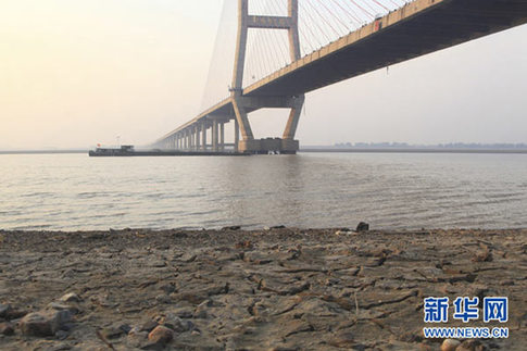 這是12月10日在江西省湖口縣境內的鄱陽湖大橋附近拍攝的已經干涸開裂的湖灘。