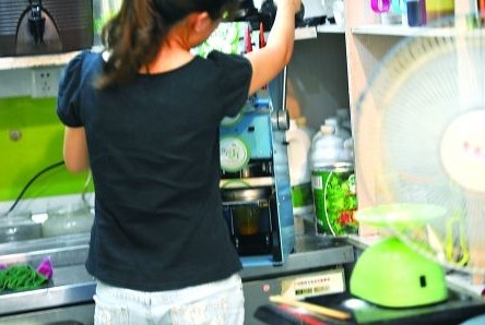 昨日，沙坪壩區(qū)一飲料店，店員在用添加劑勾兌果汁