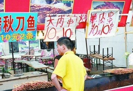 被查后，美食街上的'羊肉串'的'羊'字被涂抹了。