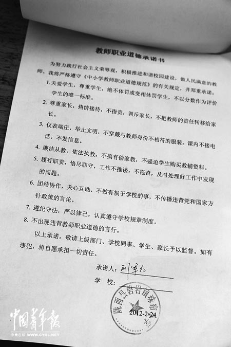 劉軍紅簽字的教師職業(yè)道德承諾書(shū)。本報(bào)記者 張鵬攝