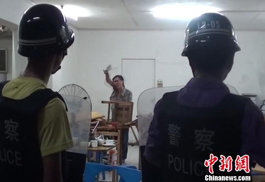 圖為涉嫌販毒的男子持菜刀在宵夜店與民警對峙。 劉志強(qiáng) 攝