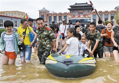 昨日，消防戰(zhàn)士在秦皇島市山海關(guān)火車站涉水運送旅客。當(dāng)日，受持續(xù)強降雨影響，河北省秦皇島市海港區(qū)、山海關(guān)區(qū)等地出現(xiàn)內(nèi)澇，部分列車停運。 新華社發(fā)
