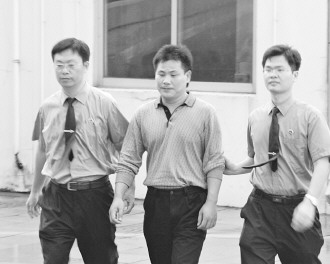 圖為陳建學(xué)被押送接受審訊。吳曉鋒攝
