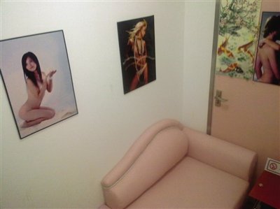取精室內(nèi)，有一個粉色沙發(fā)，墻壁四周掛著女體畫