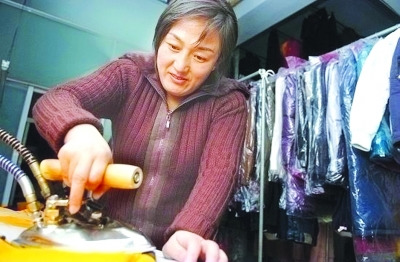 資料圖：鄒春蘭在自己洗衣店內(nèi)工作。圖片來源 揚子晚報
