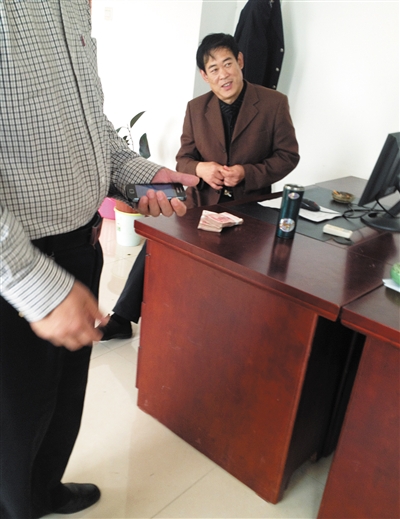 10月29日，獻(xiàn)縣國稅局稽查局辦公室內(nèi)，一名企業(yè)主交了兩萬元現(xiàn)金在桌上。新京報(bào)記者 孟祥超 攝
