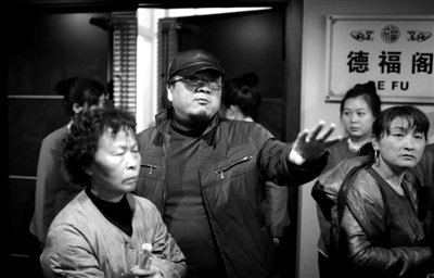 昨日，在河北香河天下第一城，相關(guān)負(fù)責(zé)人（左二）走出會(huì)議室與參加演出的老人們溝通。