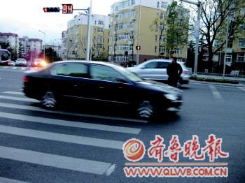 一位行人在燕兒島路與寧夏路路口闖紅燈被困在車(chē)流中。