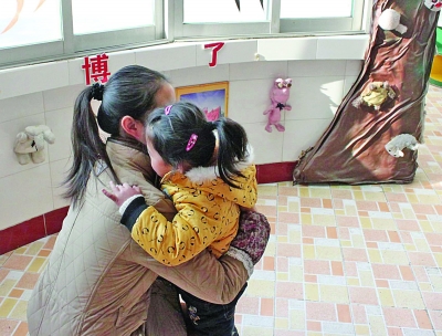 江都商貿(mào)幼兒園一位老師在擁抱該園的孩子。因?yàn)樯婕笆召M(fèi)，作為該園精品教育的一個(gè)項(xiàng)目，老師的擁抱行為也被質(zhì)疑。 董鑫 攝
