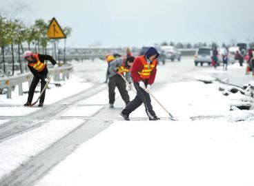 工作人員清理高速路上的積雪。 張磊攝