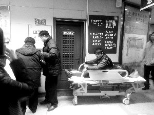 受傷工人小王坐在病床上候診。