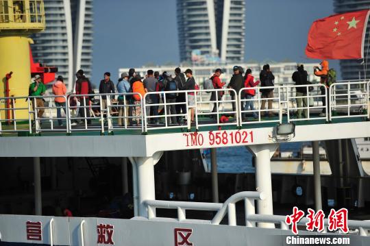 圖為24名“驢友”的“導游”被邊防的工作人員帶下船接受調(diào)查。 駱云飛 攝