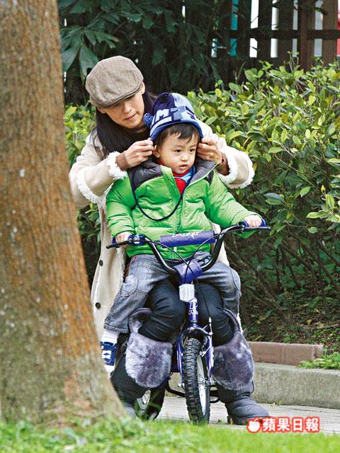 張柏芝抱quintus坐踩單車，又細(xì)心幫他整理冷帽