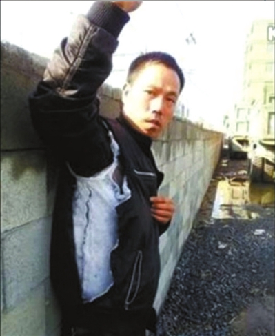 陳連弟向記者展示被撕壞的衣服。視頻截圖