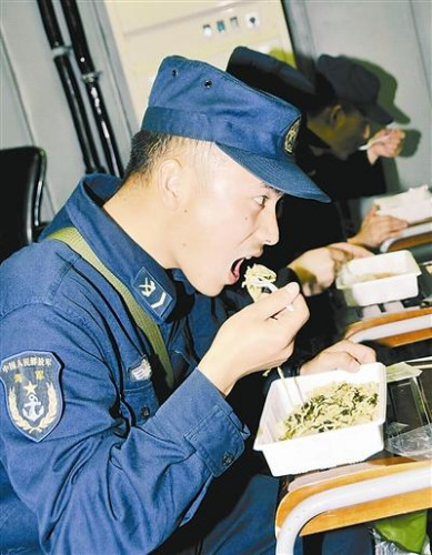 “青島”艦上的官兵在戰(zhàn)位上吃野戰(zhàn)快餐。解放軍報 記者 米晉國攝