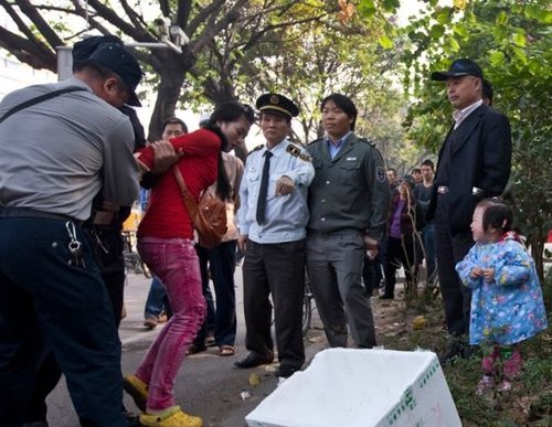 城管與女小販發(fā)生沖突后，女小販被警方強行帶走，她的孩子在一旁放聲大哭。南都記者 黎湛均 攝