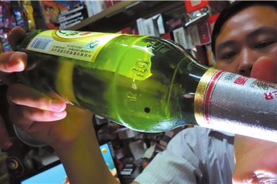 這瓶未開封的燕京啤酒內(nèi)有一顆黑色懸浮物。京華時報記者 徐曉帆 攝