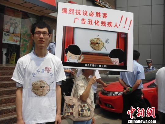 6月5日，視障人士在鄭州一必勝客門前舉牌抗議蝦球廣告歧視。 門杰丹 攝
