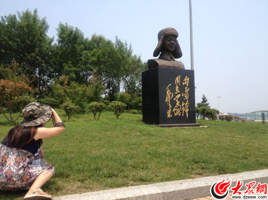 “聚焦美麗山東——第九屆中國(guó)網(wǎng)絡(luò)媒體山東行”南線采訪團(tuán)來(lái)到日照好人廣場(chǎng)，圖為記者在用攝像頭記錄好人廣場(chǎng)上的雷鋒雕像。