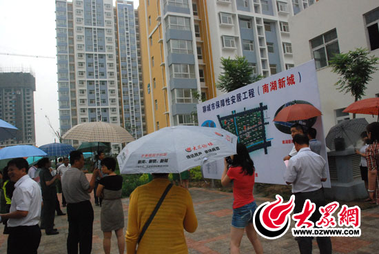 6月18日下午，西線采訪團(tuán)記者冒雨參觀了南湖新城保障房項(xiàng)目，他們?yōu)槿罕娔軐?shí)現(xiàn)安居夢而欣喜。